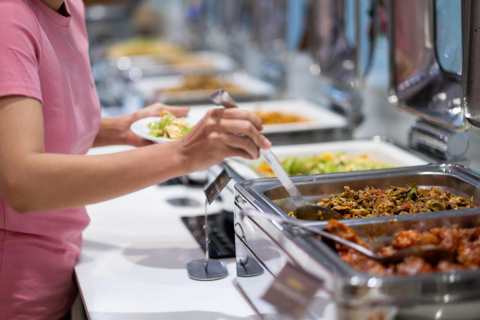 Pessoa se servindo sozinha em um buffet, sem depender de garçom.